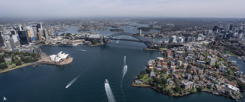 Stunning aerial view capturing Sydney Opera House and Harbour Bridge in daylight.